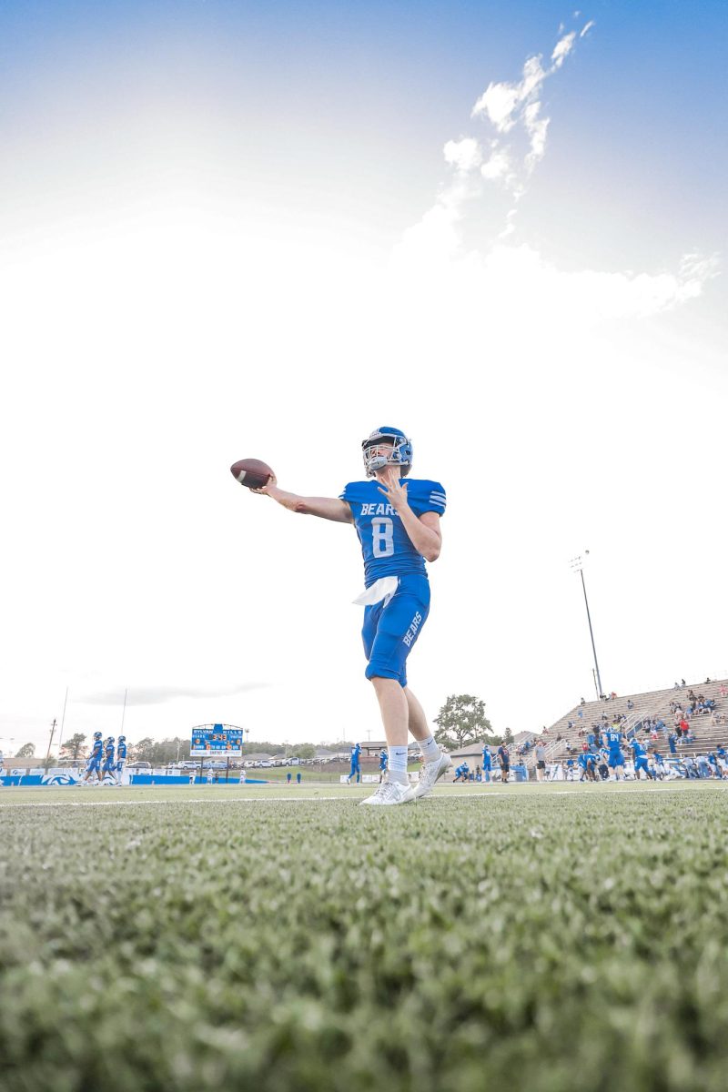 Sophomore Caden Burnett warms up his arm for the game vs. Sheridan