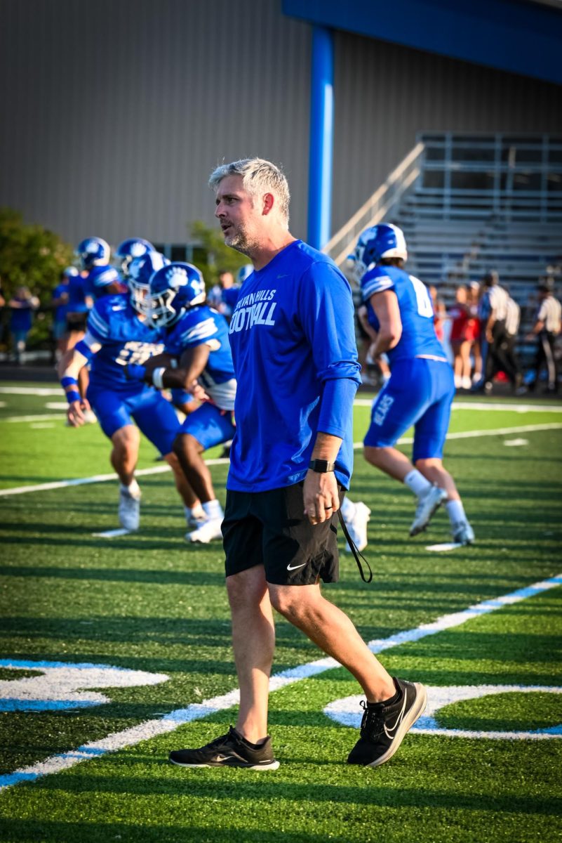 Coach Kelly talks to the players as they warm up before the game.