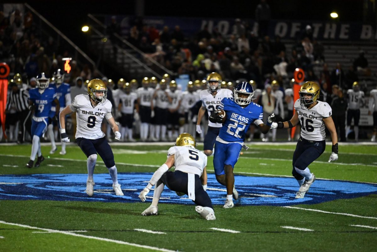 Isaiah Howell runs ball and hurdles Shiloh Player for a first down. 