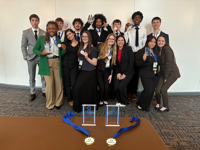 DECA competitors hold their awards after competing at the state competition.