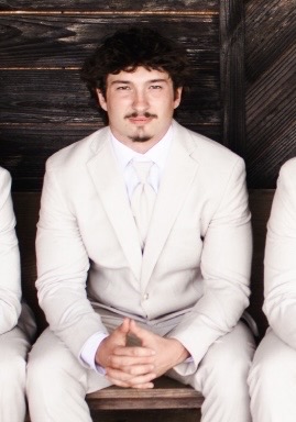 Riley Jablonowski poses for a picture during his brother's wedding at the wedding venue. 