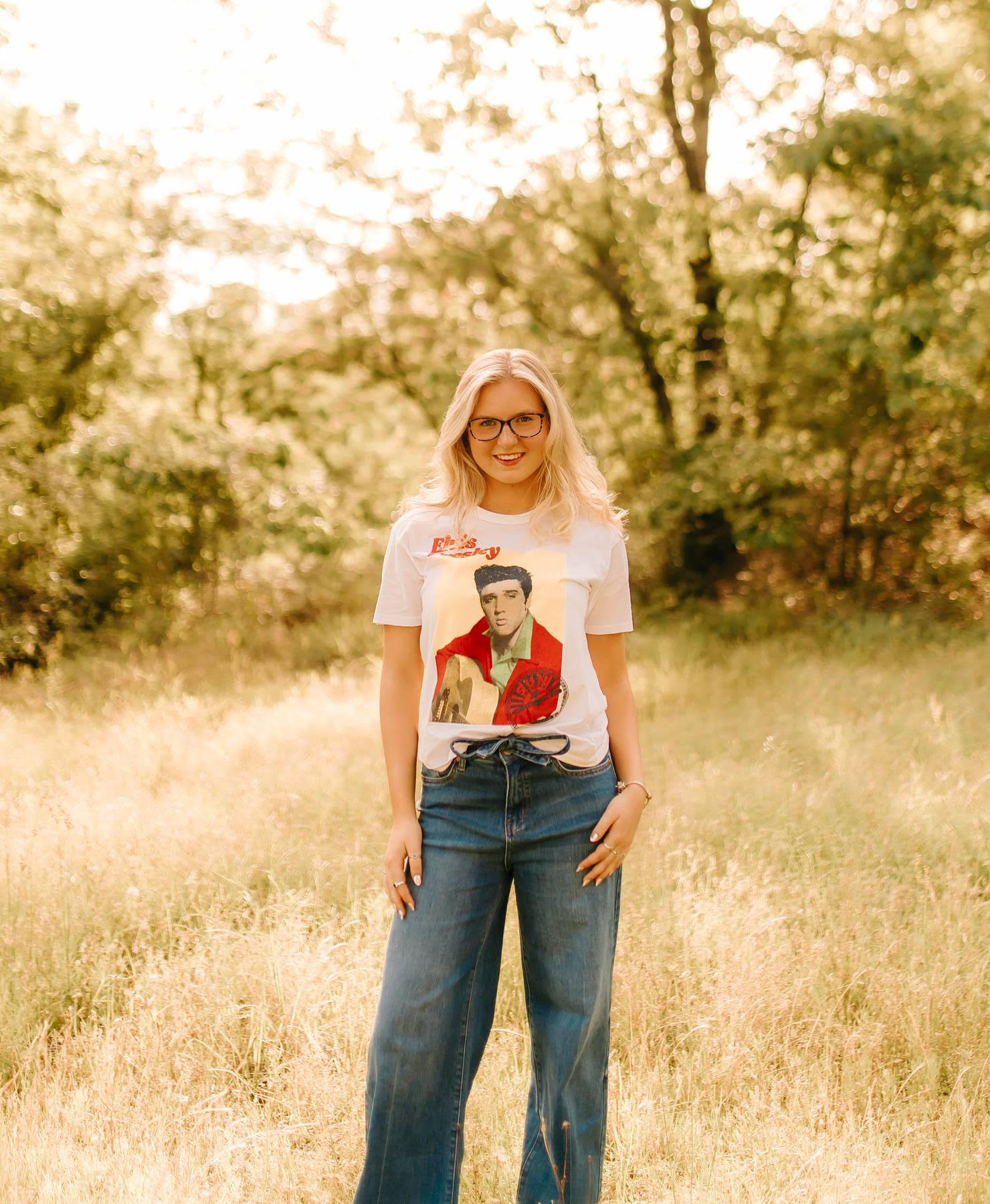 Piper Owens smiles for her senior picture in a field.