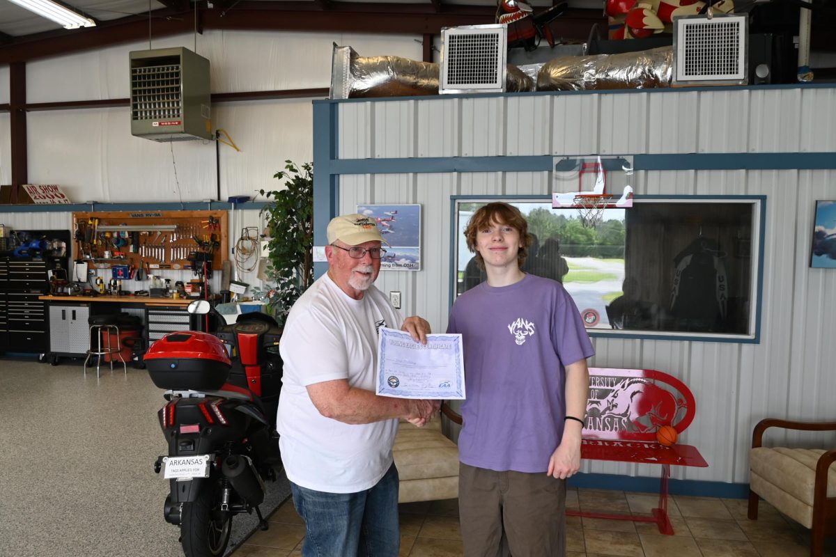 Junior Jonah Freshley smiles as pilot "Homey" Homesley presents Freshley with a Young Eagles certificate of flight. 