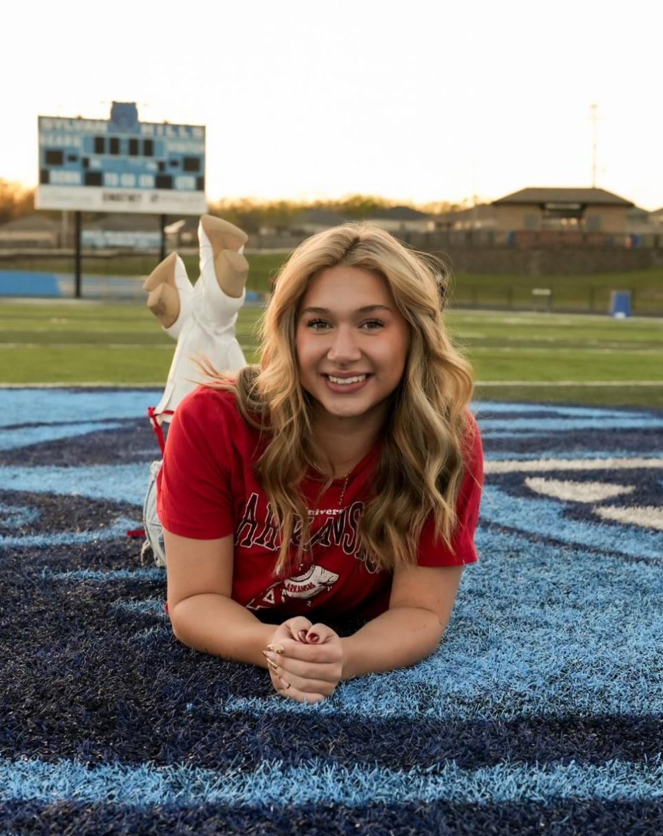 "Maddie" Sims (12) poses on the football field for a senior photo.