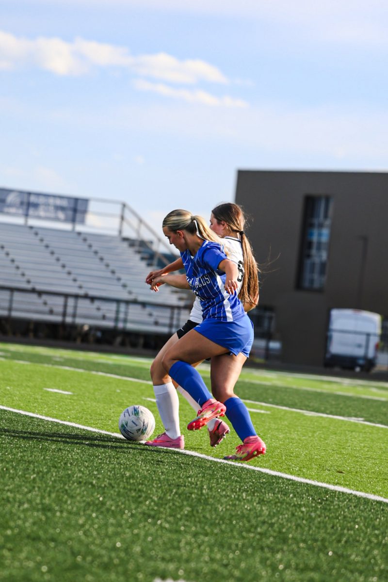 Bella Osborne (12) battles against defender in order to pass up the field.
